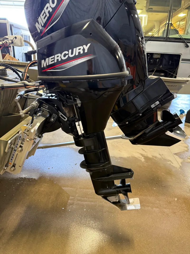 Slide: The Image of 2023 Tracker Grizzly 2072 CC Sportsman with Mercury outboard motor in a garage setting. - 5