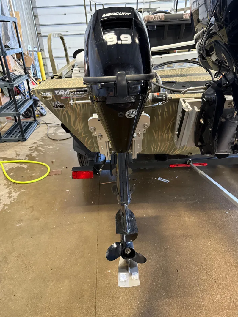 Slide: The Image of 2023 Tracker Grizzly 2072 CC Sportsman with Mercury 9.9 outboard motor in a garage setting. - 6