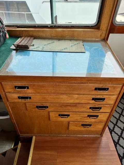 Slide: The Image of 1978 Jones-Goodell Pilothouse interior with wooden drawers and navigation map. - 14