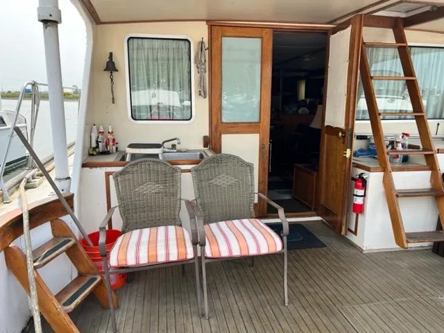 Slide: The Image of 1978 Jones-Goodell Pilothouse boat deck with chairs, sink, and wooden stairs. - 16