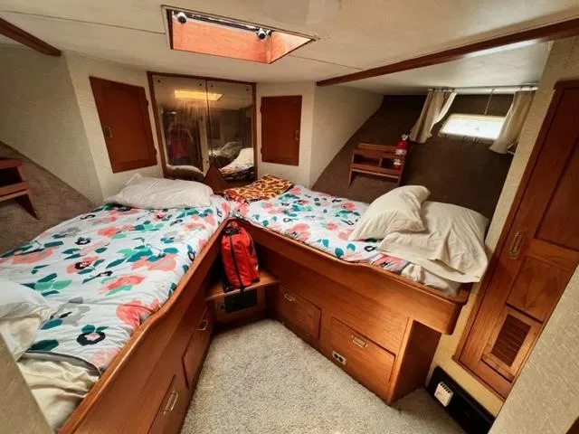 Slide: The Image of 1978 Jones-Goodell Pilothouse cabin with twin beds, floral bedding, and wooden storage cabinets. - 21