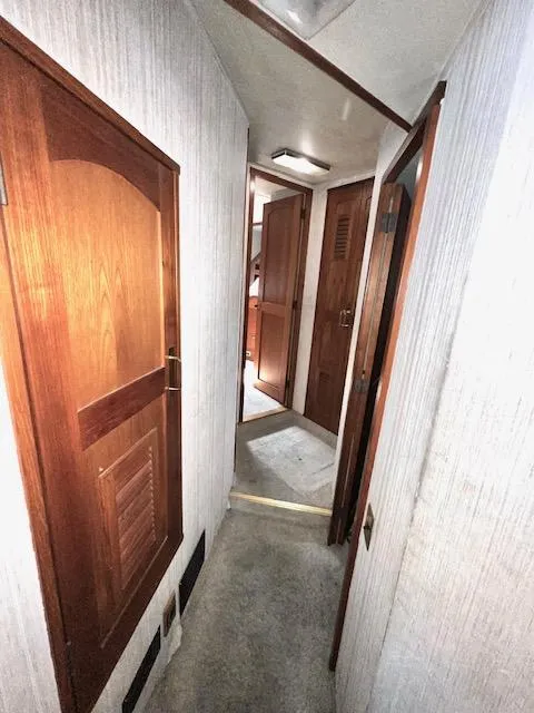Slide: The Image of 1978 Jones-Goodell Pilothouse interior hallway with wooden doors and carpeted floor. - 25