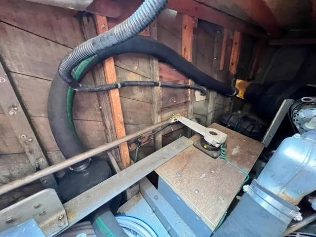 Slide: The Image of 1978 Jones-Goodell Pilothouse engine room with hoses and mechanical components. - 39