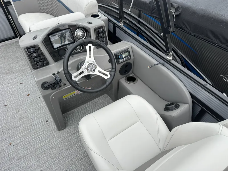 Slide: The Image of 2023 Qwest 816 Lanai LT boat interior with steering wheel and control panel. - 2