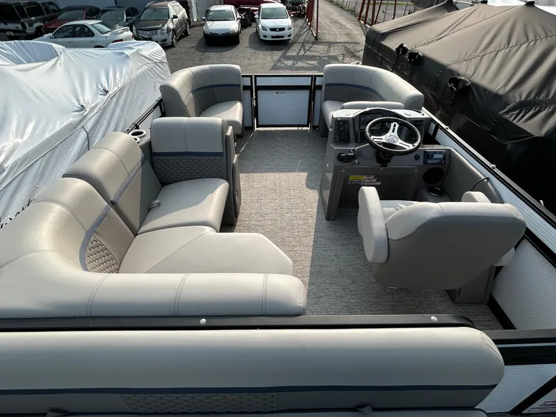 Slide: The Image of 2023 Qwest E 816 Lanai LT pontoon boat interior with plush seating and steering console. - 5