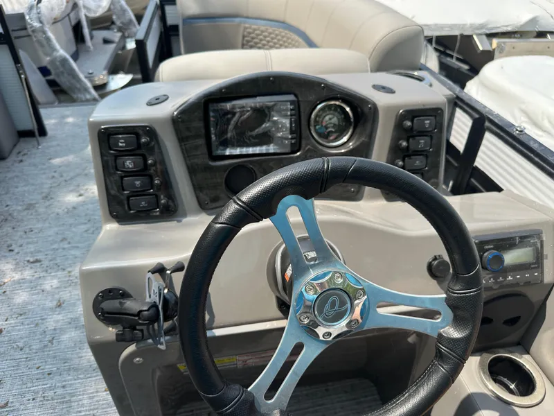 Slide: The Image of 2023 Qwest E 816 Lanai LT boat dashboard with steering wheel and controls. - 6