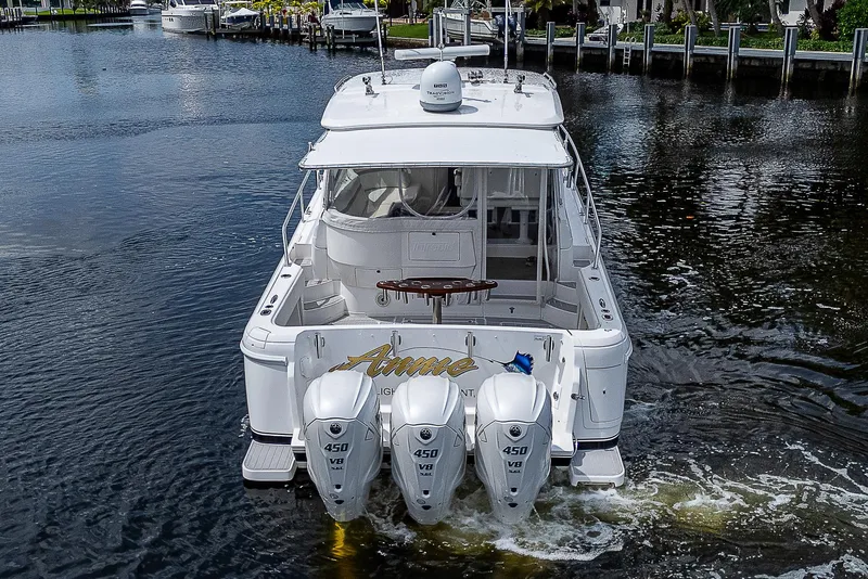 Slide: The Image of 2014 Intrepid 475 Sport Yacht with triple outboard engines on a calm waterway. - 2