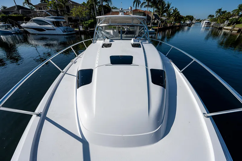 Slide: The Image of 2014 Intrepid 475 Sport Yacht on a serene waterway, showcasing sleek design and luxury. - 24