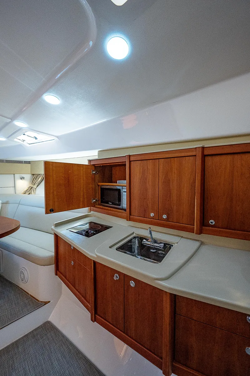 Slide: The Image of Interior of 2014 Intrepid 475 Sport Yacht with wooden cabinets and modern kitchen amenities. - 32