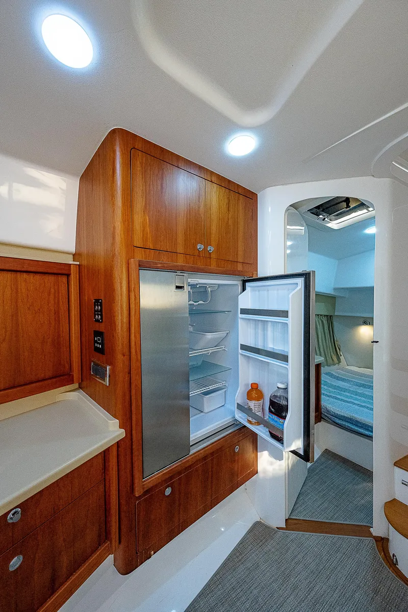 Slide: The Image of Interior of 2014 Intrepid 475 Sport Yacht with open fridge and cozy cabin. - 33