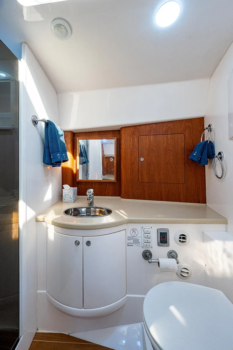 Slide: The Image of Luxurious bathroom in 2014 Intrepid 475 Sport Yacht with modern fixtures and wood accents. - 44
