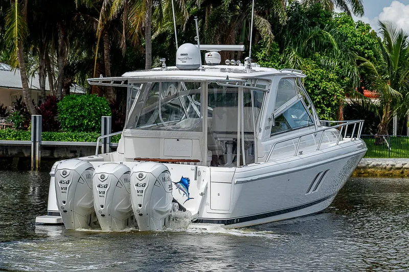 Slide: The Image of 2014 Intrepid 475 Sport Yacht with triple outboard engines cruising on a tropical waterway. - 46