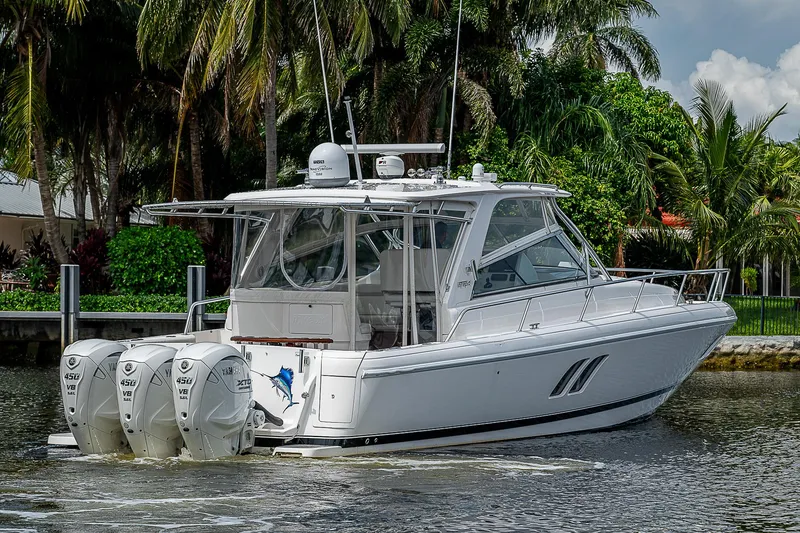 Slide: The Image of 2014 Intrepid 475 Sport Yacht with triple outboard engines on a scenic waterway. - 47