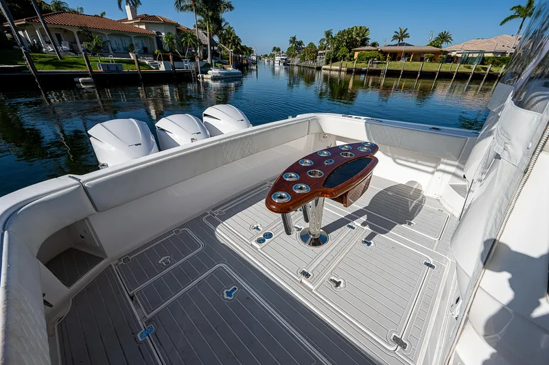Slide: The Image of 2014 Intrepid 475 Sport Yacht deck with fishing rod holders, docked in a scenic canal. - 5