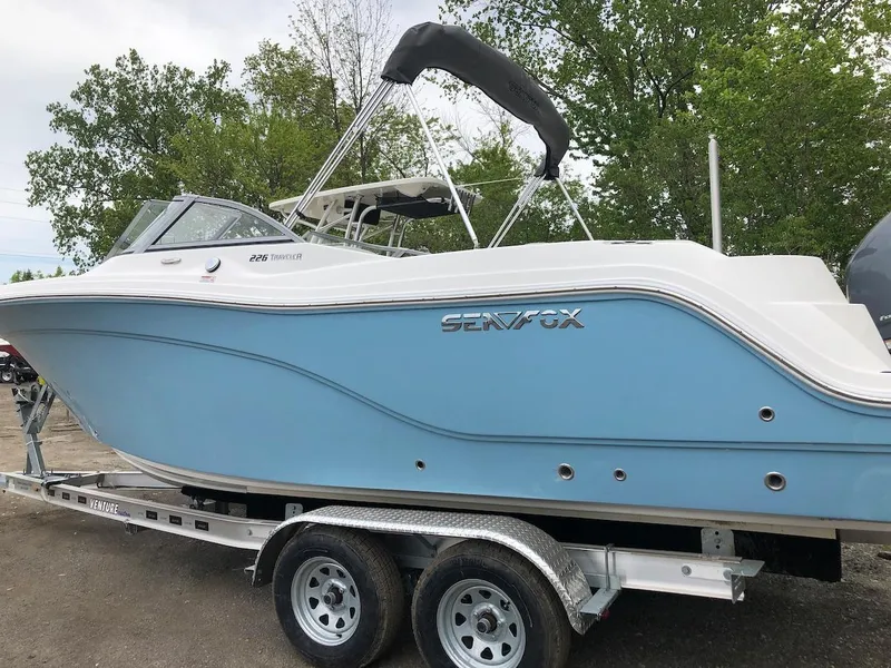 Slide: The Image of 2023 Sea Fox 226 Traveler boat on trailer, light blue hull, black bimini top. - 0