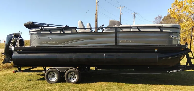 Slide: The Image of 2023 Regency 230 DL3 pontoon boat on a trailer, side view. - 2