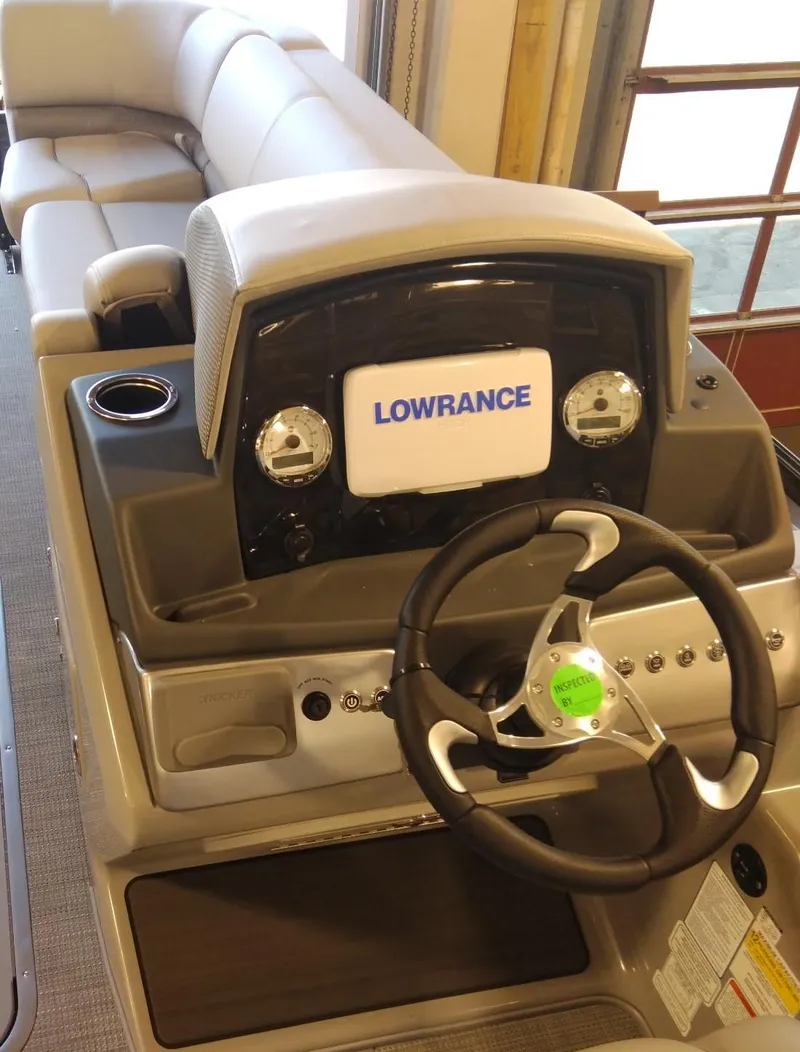 Slide: The Image of 2023 Regency 230 DL3 boat dashboard with Lowrance display and steering wheel. - 5