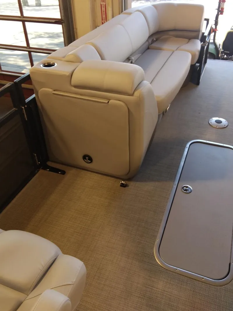 Slide: The Image of 2023 Regency 230 DL3 boat interior with plush seating and carpeted floor. - 6