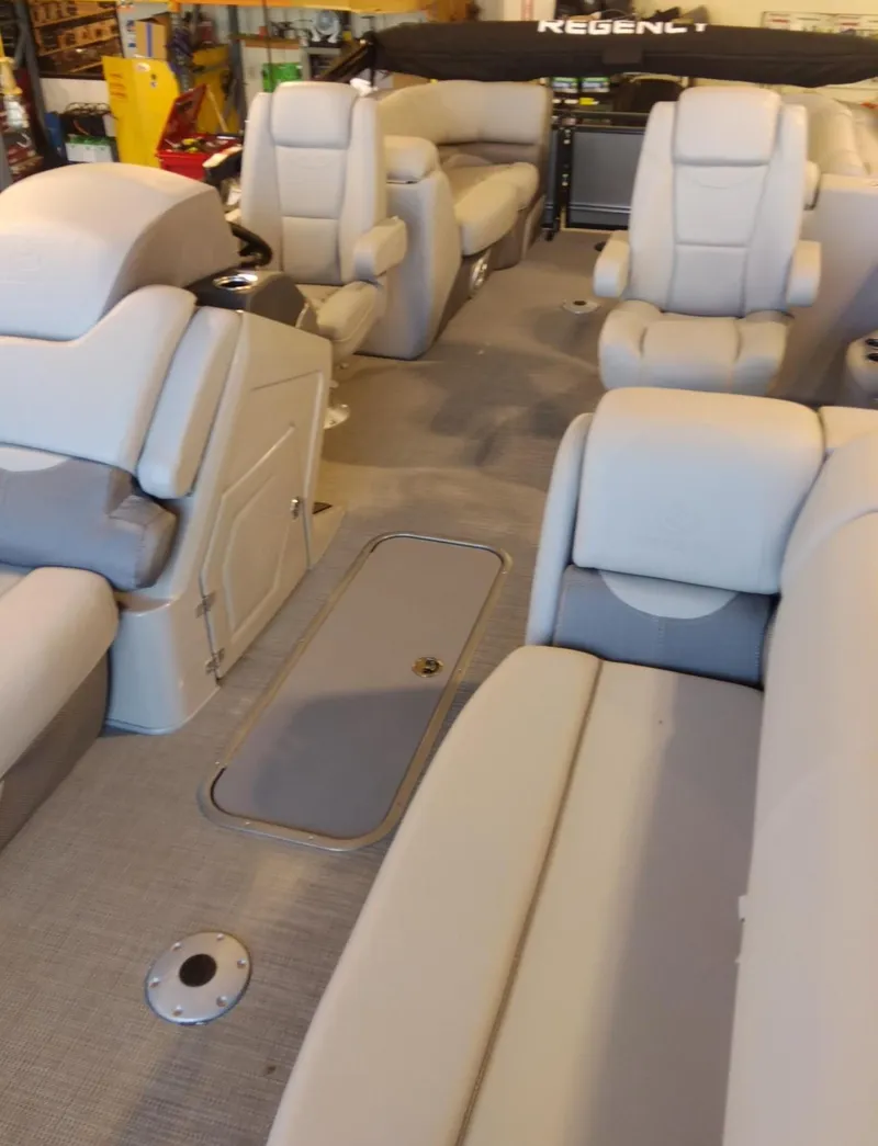 Slide: The Image of 2023 Regency 230 DL3 pontoon boat interior with plush seating and spacious layout. - 7