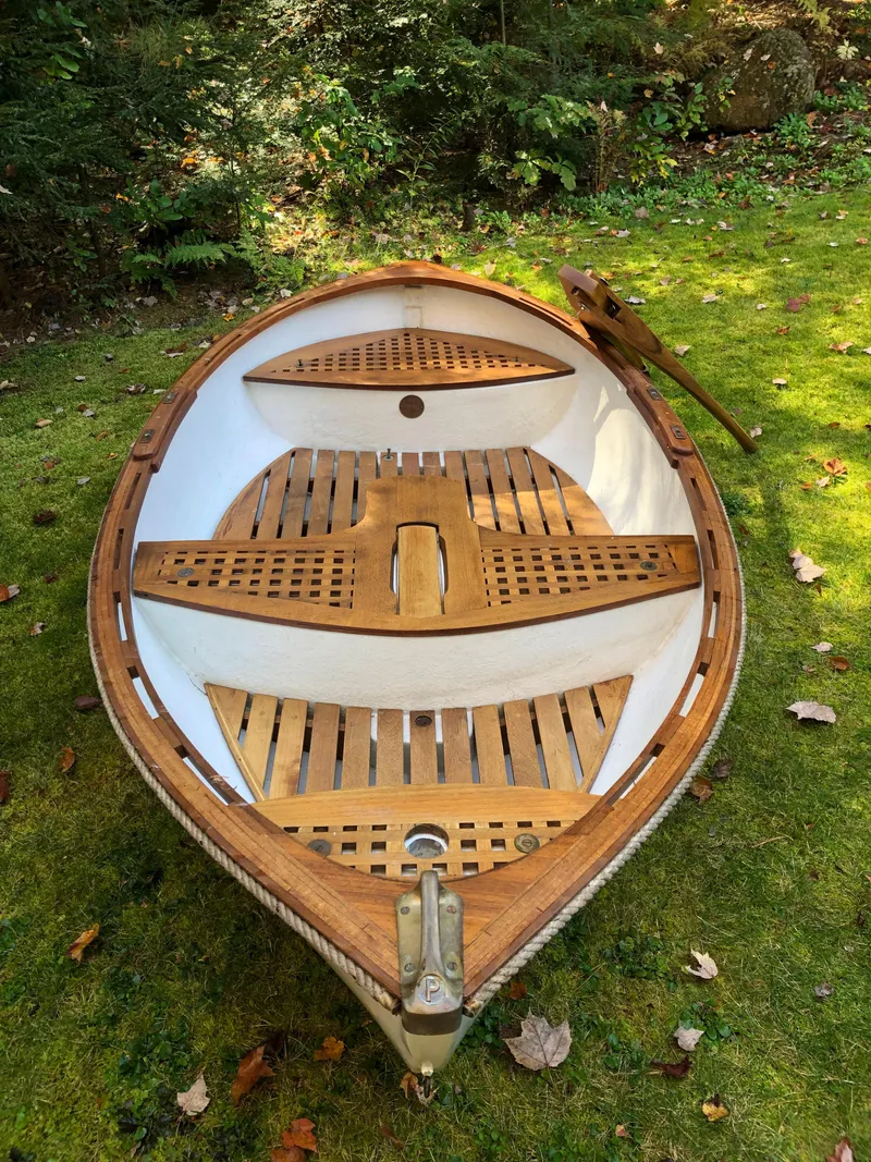 The Image of 1980 Tender Perrywinckle boat on grass, showcasing wooden interior and classic design. - 0