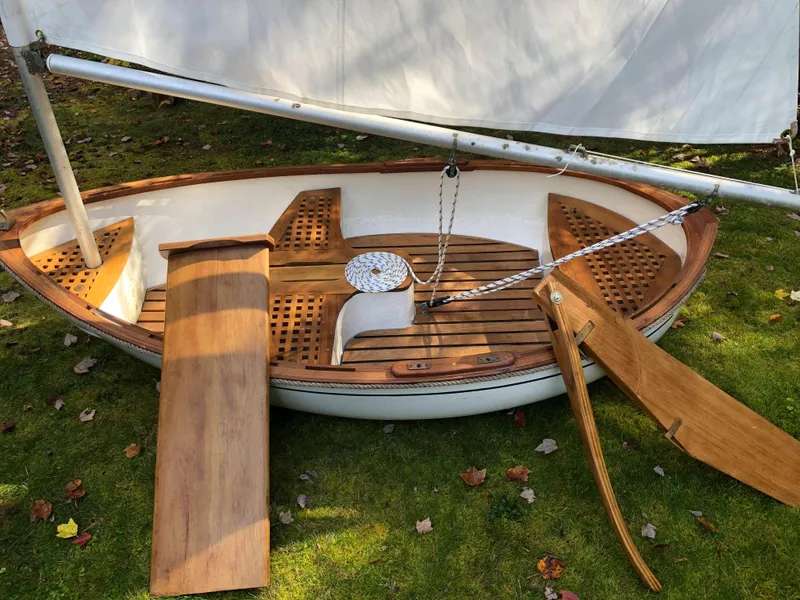 Slide: The Image of 1980 Tender Perrywinckle sailboat with wooden deck, displayed on grass. - 2