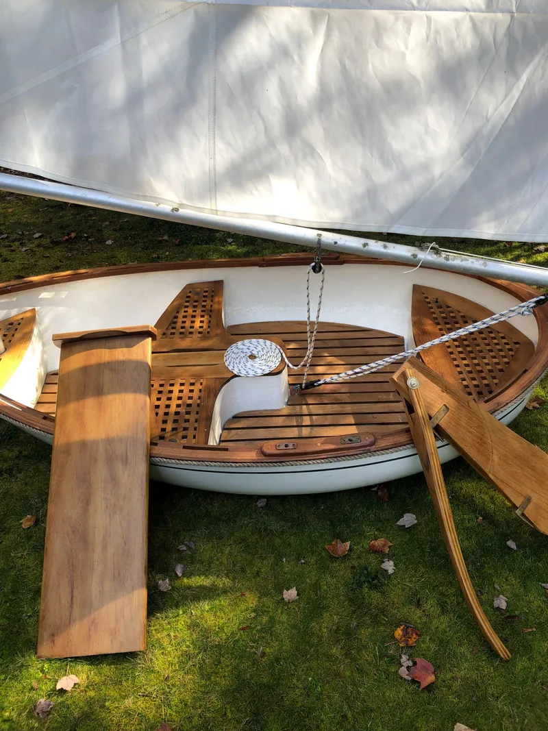 Slide: The Image of Vintage 1980 Tender Perrywinckle sailboat with wooden deck and white sail on grass. - 3