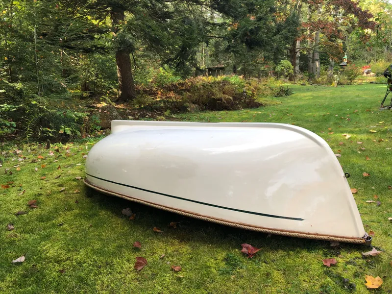 Slide: The Image of 1980 Tender Perrywinckle boat upside down on grassy lawn, surrounded by trees. - 5