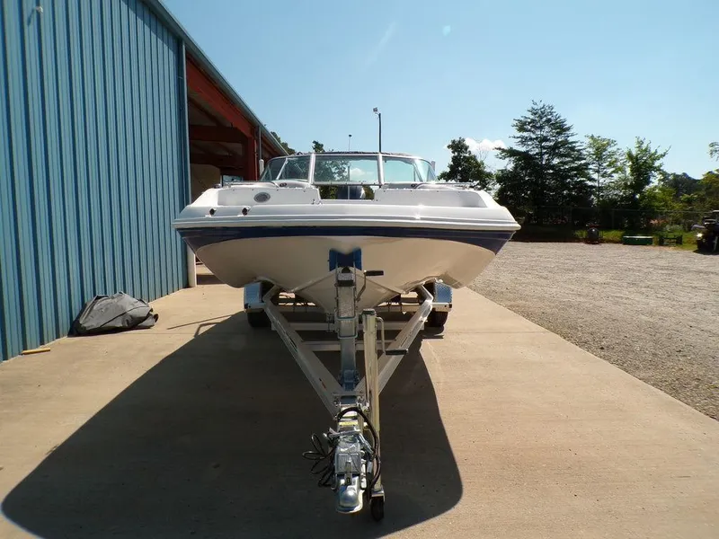 Slide: The Image of 2023 Hurricane SunDeck 187 OB boat on a trailer outside a blue building. - 7