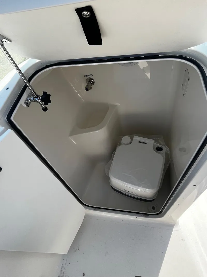 Slide: The Image of 2024 Key West 203 DFS boat interior storage compartment with portable toilet. - 7