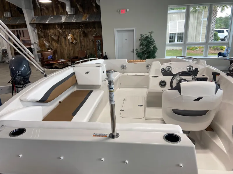Slide: The Image of 2024 Starcraft SVX 171 boat interior with seating and steering console in showroom. - 5