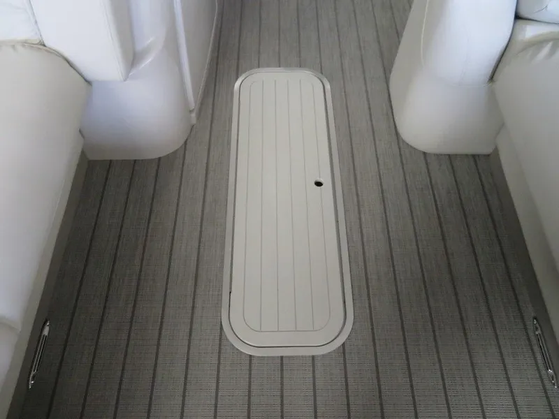 Slide: The Image of 2023 Starcraft SX 25 Q boat interior with gray flooring and storage compartment. - 13