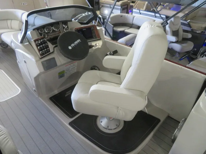Slide: The Image of 2023 Starcraft SX 25 Q boat cockpit with captain's chair and control panel. - 19
