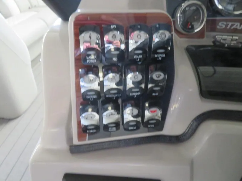 Slide: The Image of Control panel of a 2023 Starcraft SX 25 Q boat with various switches and gauges. - 23