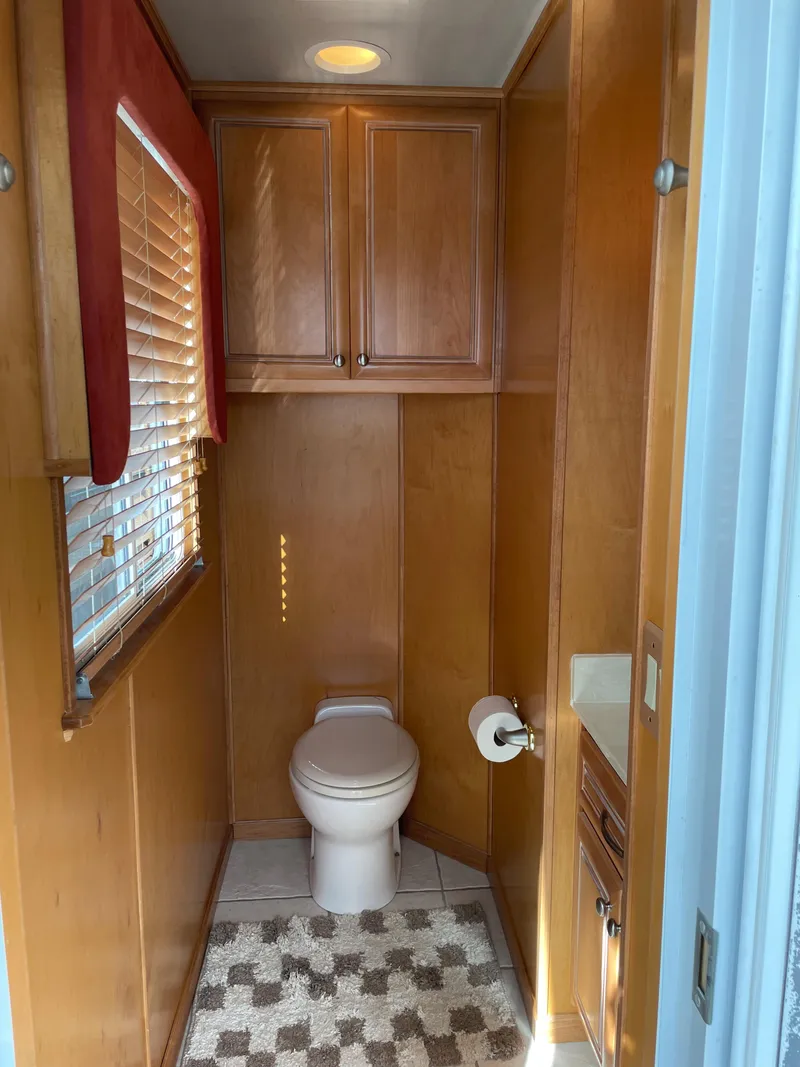 Slide: The Image of 2002 Stardust Cruisers houseboat bathroom with wooden cabinets and window blinds. - 13