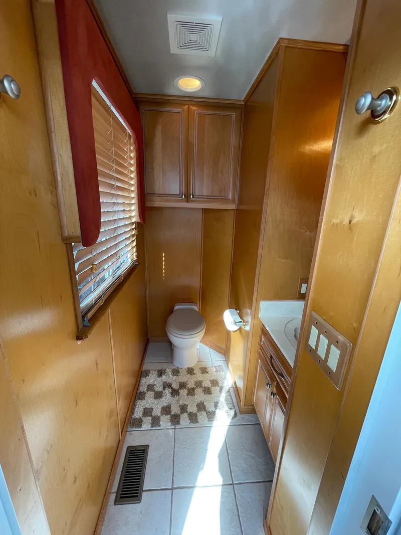 Slide: The Image of 2002 Stardust Cruisers houseboat bathroom with wooden cabinets and tiled floor. - 14