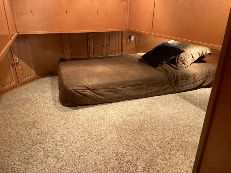 Slide: The Image of Cozy bedroom in a 2002 Stardust Cruisers houseboat with brown bedding and carpeted floor. - 16