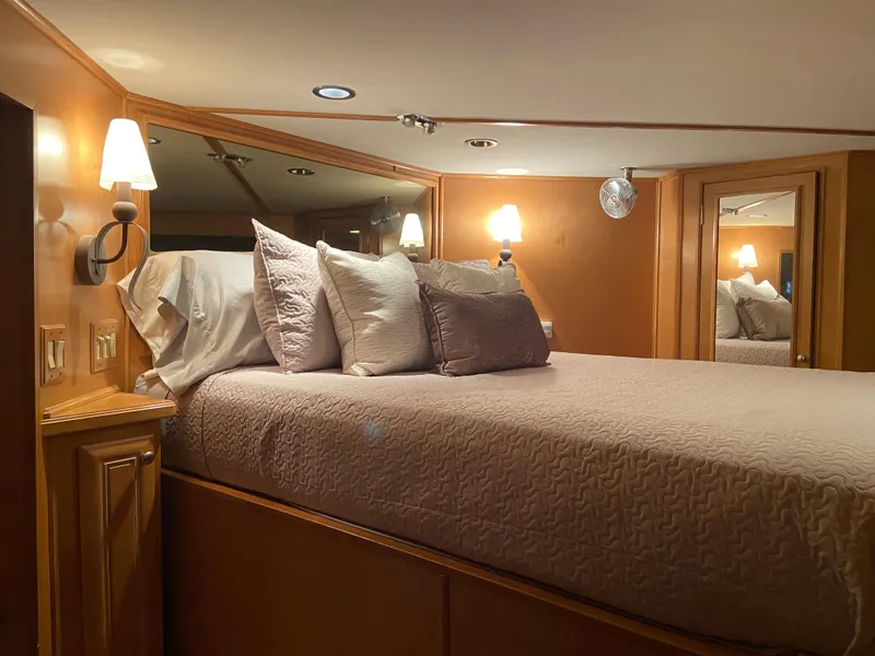 Slide: The Image of Luxurious bedroom interior of a 2002 Stardust Cruisers houseboat with cozy lighting and plush bedding. - 19