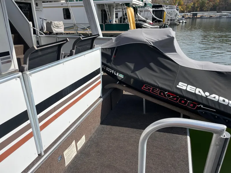 Slide: The Image of 2002 Stardust Cruisers houseboat with a covered Sea-Doo jet ski on the deck. - 24