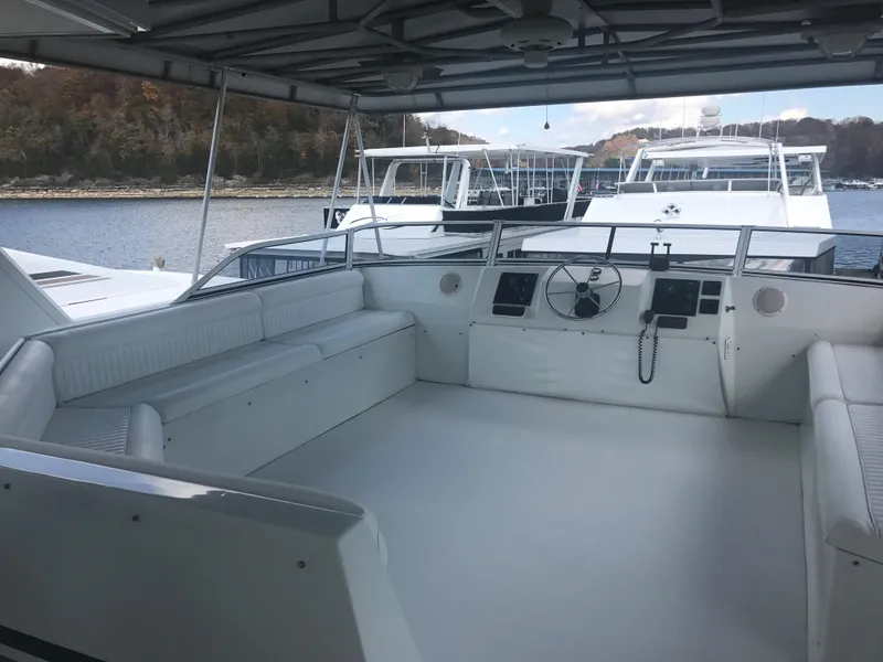 Slide: The Image of 2002 Stardust Cruisers houseboat interior with white seating and steering area. - 30