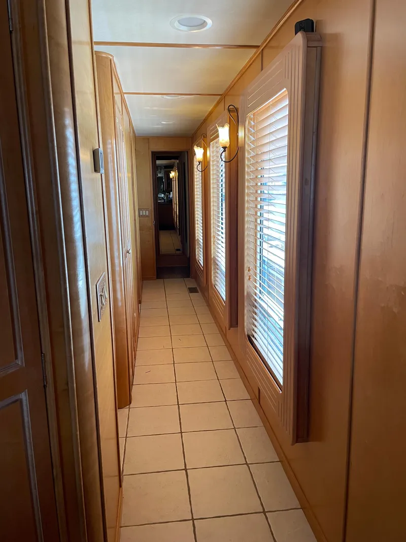 Slide: The Image of Interior hallway of 2002 Stardust Cruisers houseboat with wooden walls and tiled floor. - 7