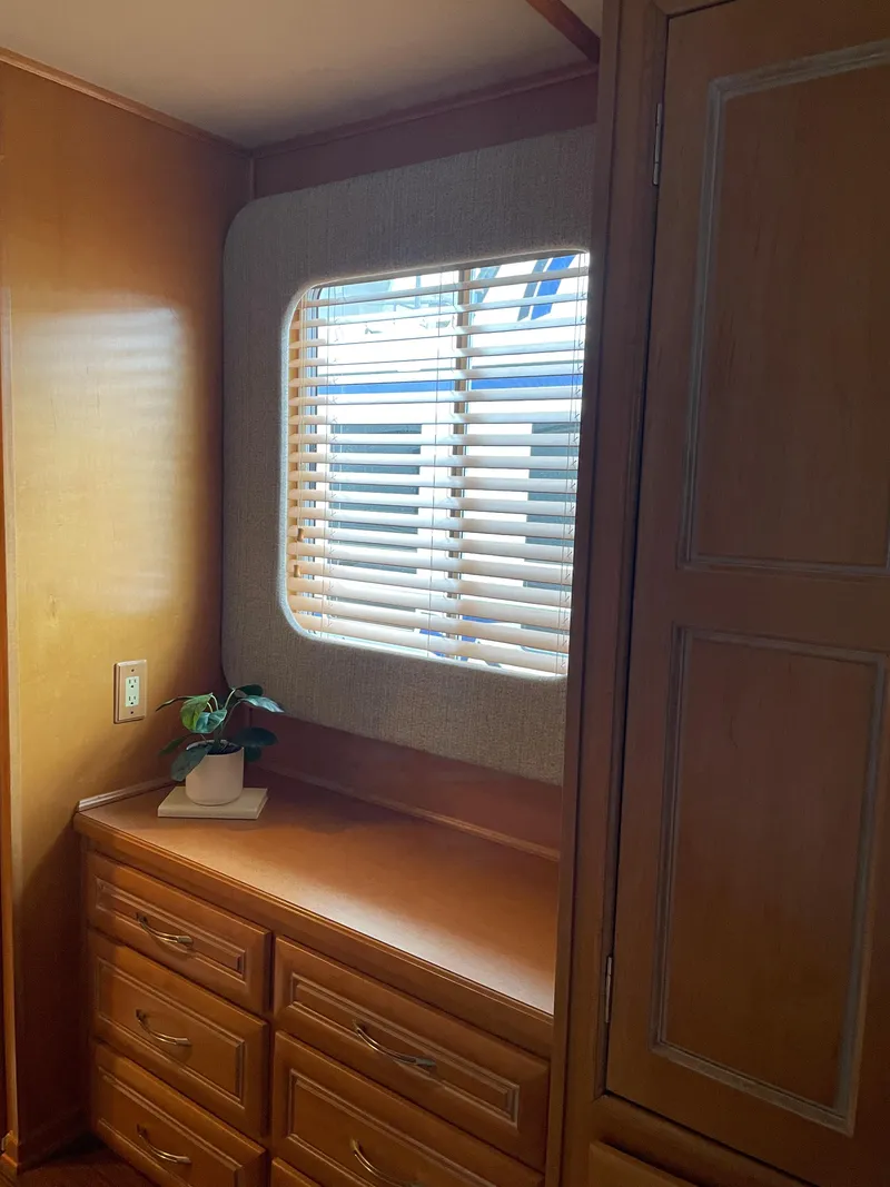 Slide: The Image of 2002 Stardust Cruisers Houseboat interior with wooden cabinets and window blinds. - 8