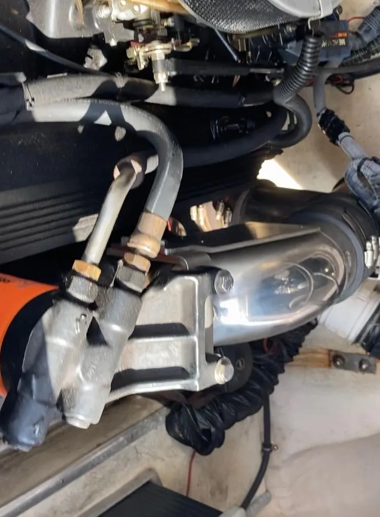 Slide: The Image of Engine components of a 1997 Donzi 22ZX boat, featuring hoses and metal parts. - 11