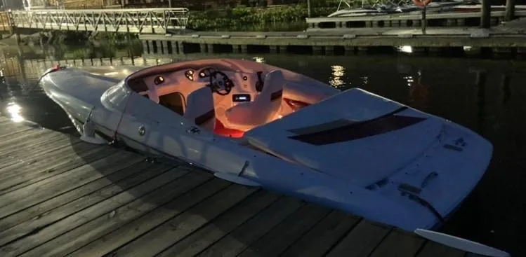 Slide: The Image of 1997 Donzi 22ZX boat docked at night with illuminated interior. - 17