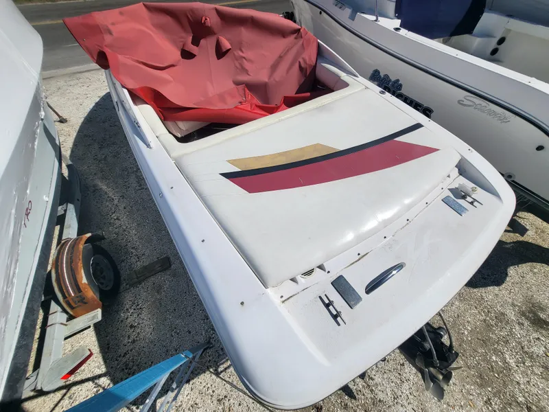 Slide: The Image of 1997 Donzi 22ZX boat with red cover, parked on gravel. - 23
