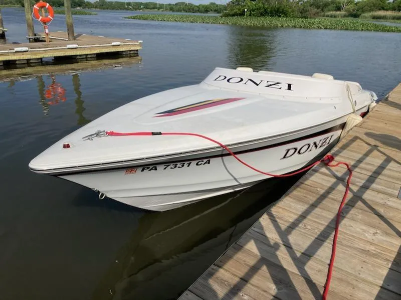 Slide: The Image of 1997 Donzi 22ZX speedboat docked on a calm lake. - 4