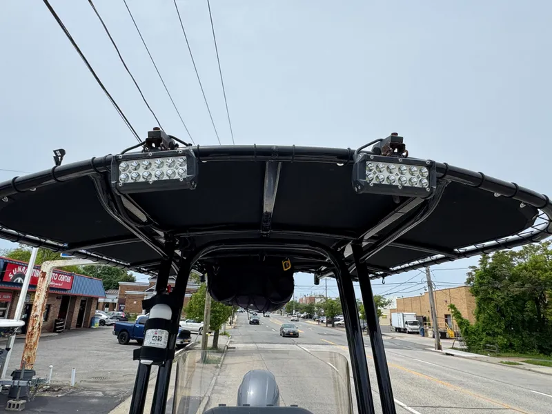 Slide: The Image of 2018 Robalo R200 Center Console boat with T-top and mounted LED lights. - 18