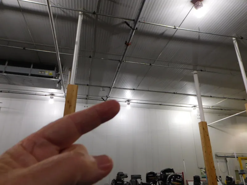 Slide: The Image of Person pointing inside a warehouse with high ceilings and industrial lighting. - 18