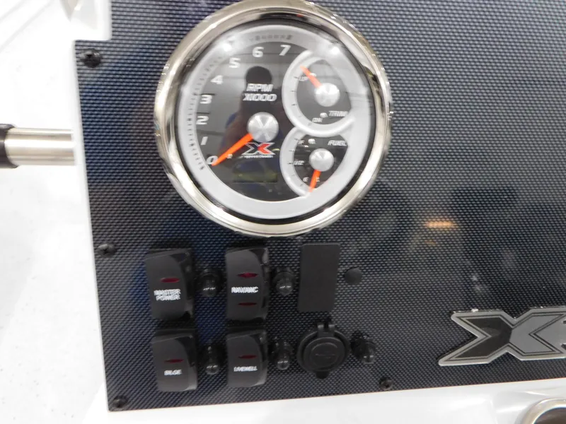 Slide: The Image of 2023 Xpress H190B boat dashboard with gauges and control switches. - 12