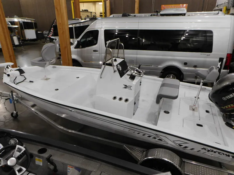Slide: The Image of 2023 Xpress H190B boat in showroom, side view with seating and console. - 3