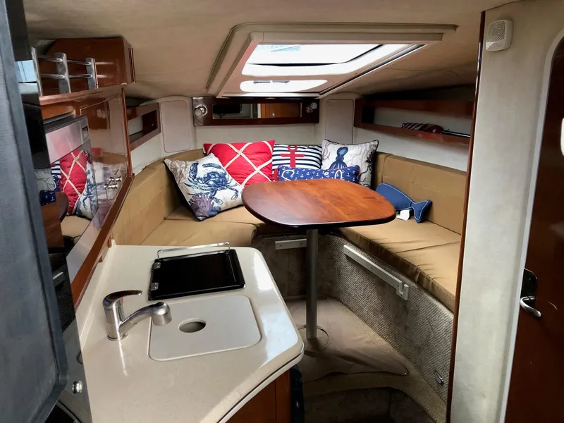 Slide: The Image of Interior of 2009 Sea Ray 270 Sundancer with cozy seating, table, and kitchenette. - 19